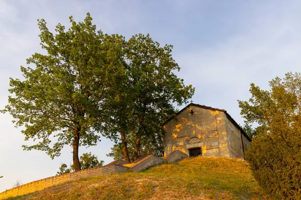 İtalya, Piedmont, Treville kırsalında küçük bir kiliseyi aydınlatan güneş ışığı.