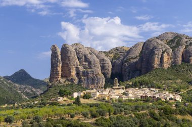 Huesca, Aragon, İspanya 'daki etkileyici Mallos de Riglos kaya oluşumları arasında yer alan geleneksel evleriyle Aguero köyünün manzarası