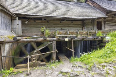 Slovakya 'nın Kvacany köyü açık hava müzesindeki eski ahşap evin yakınındaki geleneksel Slovakya su değirmeninin su güç veren ahşap tekerleği.