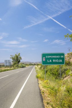 İspanya 'da La Rioja Cemaati' ne giren boş bir yol. Güneşli bir yaz gününde mavi gökyüzünde zıtlıklar var.