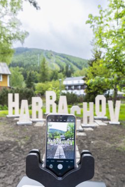 Üç ayaklı akıllı telefon, Liberecky Kraj, Çek Cumhuriyeti 'ndeki dağlı Harrachov tabelasını yakalıyor.