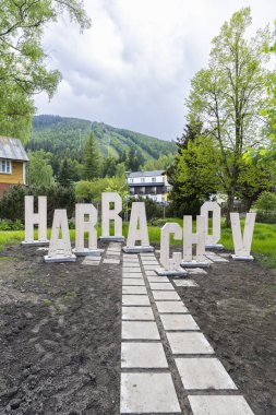 Büyük ahşap harflerle Harrachov yazılıyor. Arkasında Certova Hora Dağı var. Çek Cumhuriyeti 'nin Liberecky Kraj şehrinde yer alıyor.