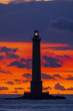 Phare de la Hague deniz fenerinin silueti Normandiya, Fransa 'da canlı bir günbatımı gökyüzüne karşı