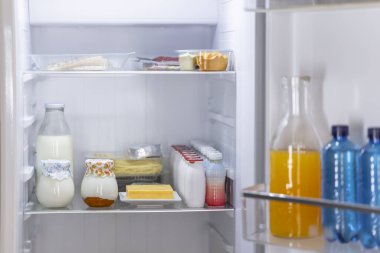 Open refrigerator full of food and drinks promoting healthy eating habits and demonstrating food storage