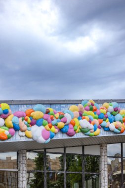 Chvalovice, Çek Cumhuriyeti 'nde bulutlu bir gökyüzünün altında bina dekore eden renkli balonlar.