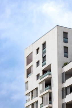 Montpellier, Fransa 'da, bulutlu mavi gökyüzüne karşı balkonları ve panjurları olan modern beyaz apartman.