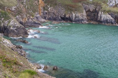Fransa 'nın Brittany kentindeki Pointe de Brezellec yakınlarındaki bir koyda kayalara çarpan güzel turkuaz suyu.