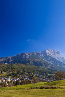 Güneşli bir sonbahar gününde Dolomitlerdeki görkemli Peralba Dağı 'nın altındaki Sappada köyü.