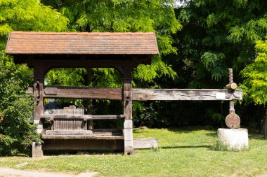 Parktaki eski ahşap şarap presi geleneksel şarap yapma metodunu gösteriyor.