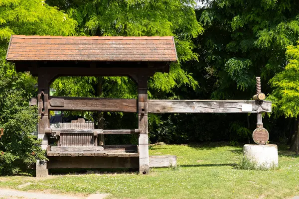 Parktaki eski ahşap şarap presi geleneksel şarap yapma metodunu gösteriyor.