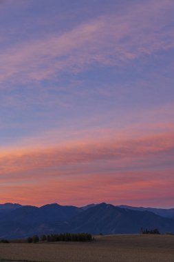 Slovakya dağları üzerinde renkli bir gün doğumu, pembe ve mor renkler gökyüzüne hakim.