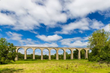 Figeac, Lot, Occitanie yakınlarındaki Fransız kırsalında güzel bulutlu bir gökyüzünün altında antik bir demiryolunun panoramik görüntüsü