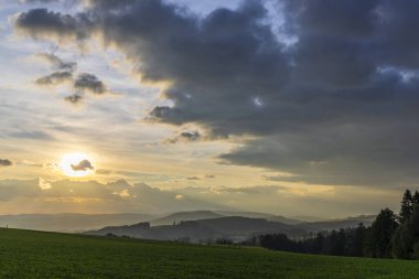 Çekoslovakya 'nın Chvalec kentindeki bulutların ardında güneş batıyor
