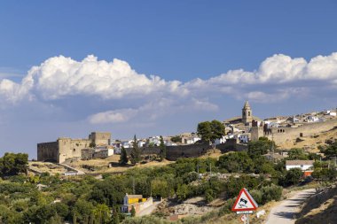 Sabiote 'nin heybetli kalesi, kilisesi ve güçlendirilmiş duvarlarıyla tarihi şehir manzarası Jaen, Endülüs, İspanya' da bulutlu bir gökyüzü altında pitoresk bir manzara yaratıyor.