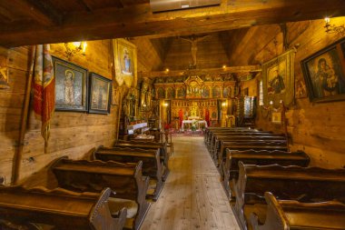 Polonya 'nın Muszyna kentindeki tarihi bir kilisede tahta sıralar ve sunaklar.