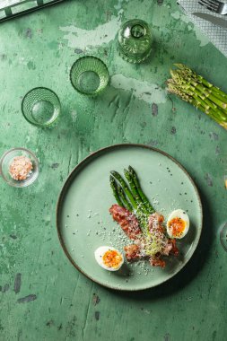 Kuşkonmaz ve haşlanmış yumurta içeren zarif bir kahvaltı tabağı.