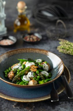 Kırsal bir masada istiridye, kuşkonmaz ve kremalı sos içeren zarif bir yemek.