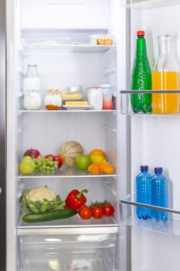 Meyve, sebze ve içeceklerin düzgünce sergilendiği açık buzdolabı.