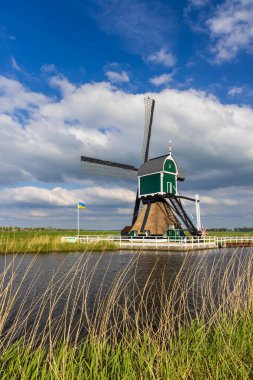 Hollanda 'nın Groot Ammers, Hollanda' da tarihi bir yel değirmeni manzarası ülkenin ikonik mimarisi ve sakin manzarasını gözler önüne seriyor.