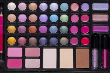 Renkli göz farı, allık, ruj ve dudak parlatıcısı içeren profesyonel makyaj seti güzellik geliştirme için çeşitli seçenekler sunuyor.