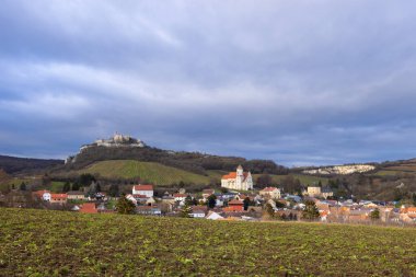 Avusturya 'nın Aşağı kesimindeki Falkenstein şehrinde bulutlu bir gökyüzünün altındaki ortaçağ kalesi olan Falkenstein Kalesi' nin panoramik manzarası.