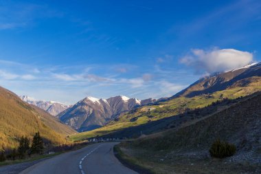 Val d 'Oronaye, Alpes de Haute Provence, Fransa' daki D900 yolu boyunca karlı zirveler ve yemyeşil vadilerle nefes kesici dağ manzarası
