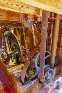 Paslı kemer ve makara ile eski ahşap vites iletimi kereste fabrikasına enerji aktarıyor.