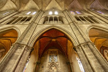 Bourges, Fransa 'daki Bourges Katedrali' nin içindeki gotik mimarinin düşük açılı görüntüsü. Kemerleri, sütunları ve boyalı camları gösteriyor.
