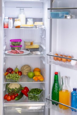 Taze ve sağlıklı yiyecek, içecek, meyve, sebze, et ve süt ürünleri içeren açık buzdolabı