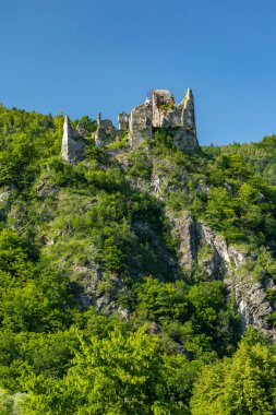 Lietava Kalesi kalıntıları, açık mavi gökyüzünün altında yemyeşil ormanlarla çevrili Slovakya 'nın Zilina Bölgesi' ndeki bir tepenin üzerinde tünemiştir.