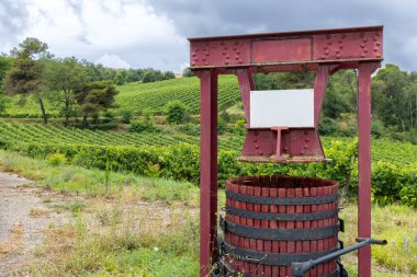 Geleneksel şarap presi Fransa 'nın Pieusse bağlarında bulutlu gökyüzünün altında duruyor.