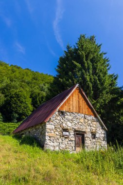 Geleneksel taş ahır Fransa 'nın Aulus les Bains kentindeki Pireneler' in manzarasına yuva yapmış.