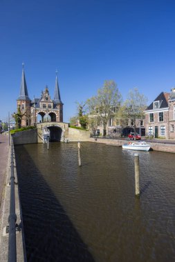 Sneek, Friesland 'daki tarihi Waterpoort kapısının manzarası, kanal ve geleneksel Hollanda evleri.