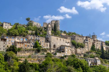 Montbrun les Bains 'in, ortaçağ mimarisi ve çarpıcı doğal çevresini gözler önüne seren bir tepenin tepesine tünemiş manzarası.