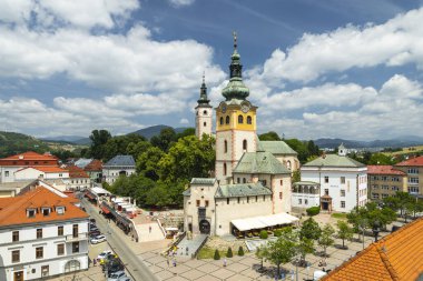 Slovakya 'nın Banska Bystrica kentindeki ana meydanın hava manzarasında güneşli bir yaz gününde Bakire Meryem' in Varsayımı Kilisesi yer alıyor.