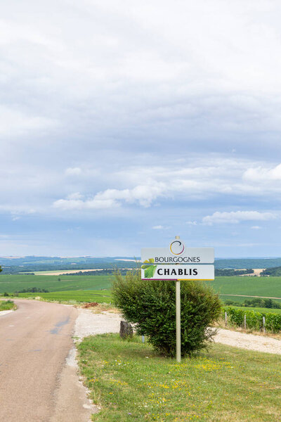 Дорожный знак, указывающий на престижный винодельческий регион Шабли в Бургундии, Франция, с виноградниками и облачным небом
