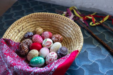 Çekoslovakya 'nın başkenti Kourim' de Paskalya kutlamalarının sembolü olan bir pomlazka ile birlikte hasır bir sepete yerleştirilmiş geleneksel czech desenlerini gösteren el yapımı Paskalya yumurtaları.