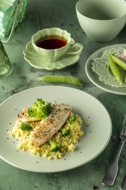 Siyah susam tohumlu ızgara beyaz balık filetosu, brokolili kuskus yatağı, sağlıklı ve dengeli yemek.