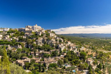 Gordes 'in panoramik manzarası, Fransa' nın Provence bölgesinin Luberon bölgesinde bir tepenin üzerine tünemiş güzel bir köy, büyüleyici taş evleri, yemyeşil ve çevresindeki vadiyi gösteriyor.