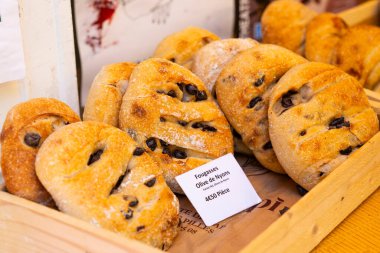 Zeytinli nefis fougasse ekmekleri, taze pişmiş ve Fransa 'nın Nyons kentindeki bir markette ahşap bir sandıkta sunuluyor.