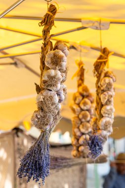 Nyons, Drome, Auvergne Rhone Alpes 'teki Fransız pazarında asılı sarımsak ve lavanta örgüleri.