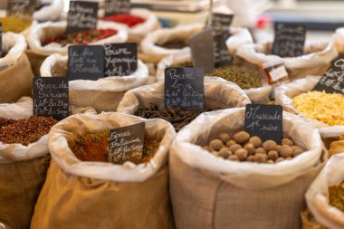 Nyons, Drome 'daki bir Fransız pazarında çuval bezlerinde sergilenen renkli baharatlar.