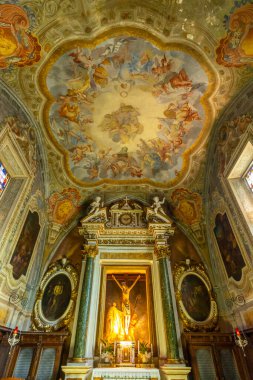 Decorated chapel interior featuring a central altar and classical ceiling painting in Monte Oliveto Maggiore