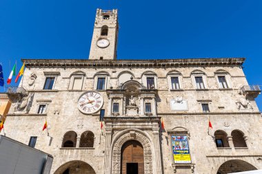 Palazzo dei Capitani displaying its historic facade with clocks and flags under a clear blue sky