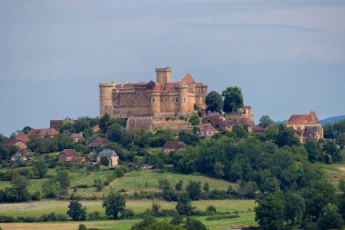 Castelnau Bressac kalesi ve köyü yeşil manzarayla çevrili bir tepenin üzerine inşa edildi.