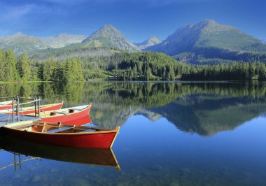 Morning landscape with Red boats on mountain lake in Tatras in Slovakia