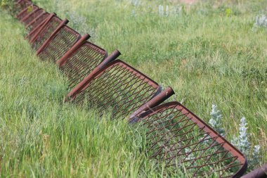 Yeşil çayır üzerindeki eski, soyut paslı çit