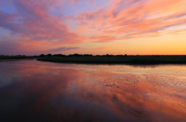 Göl yüzeyinde gün batımı gökyüzü olan manzara