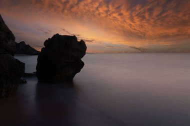 Gün batımı peyzaj üzerinde kayalık deniz
