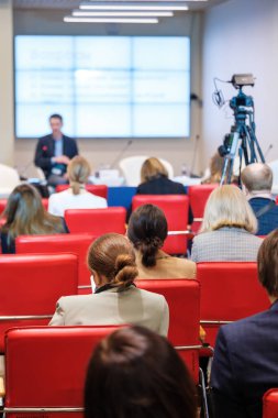 Dar oditoryumdaki iş seminerinde çevrimiçi konuşmacı dinleyen insanlar